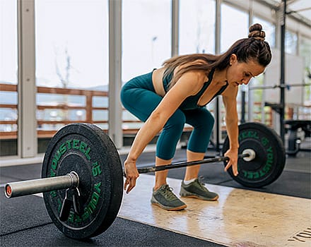 vrouw-trekt-stang-omhoog-met-dumbbells-
