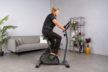 oudere-vrouw-op-hometrainer-trainen-in-woonkamer.jpg