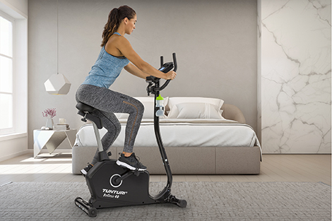 tunturi-hometrainer-ergometer-in-slaapkamer-met-vrouw-fietsend.jpg