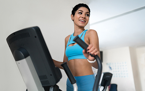 vrouw-trainend-op-crosstrainer-in-huiskamer.jpg